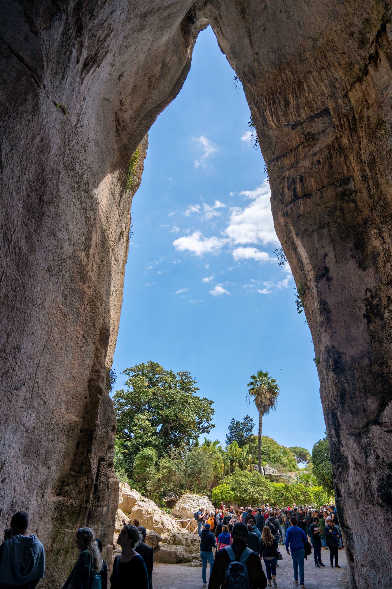 Die Grotte „Ohr des Dionysos“ fasziniert mit sichtbaren Bearbeitungsspuren im Gestein und außergewöhnlicher Akustik, die Besucher oft testen. Einer Legende zufolge ließ der Tyrann Dionysos von Syrakus hier Gefangene schuften und übernachten, um ihre Flüstergespräche dank der besonderen Akustik belauschen zu können.